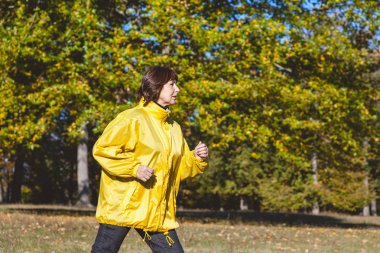 Güzel Olgun kadın sonbahar ormanda koşu