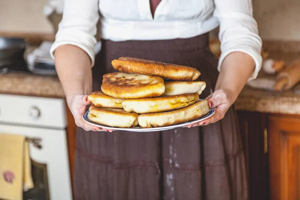 Тарелка с жареными пирогами в женских руках — стоковое фото