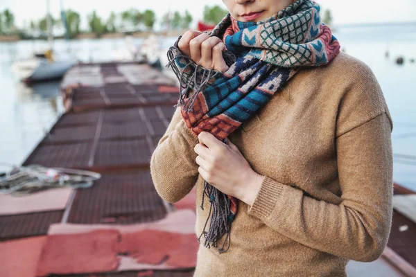 Female hands tied knot on a wool scarf — Stock Photo, Image