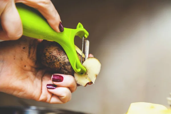 Het reinigen van aardappelen. handen van vrouw schoon aardappelen met speciale t — Stockfoto