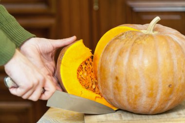 Eller erkek olgun kabak parçası büyük bıçak ile kesmek.