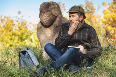 öğrenilen tarihçi önce taş heykel Höyük üzerinde oturur.