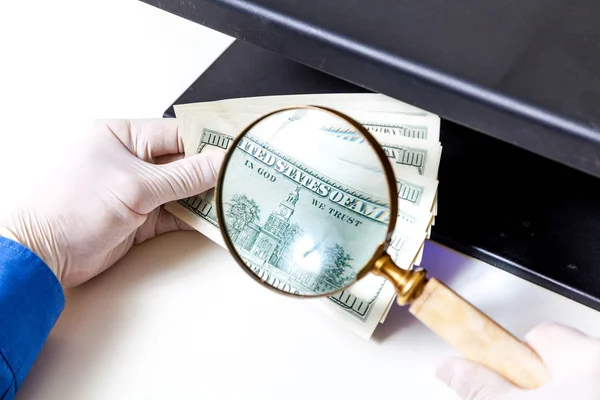 Автентифікація банкнот за допомогою збільшувального скла — стокове фото