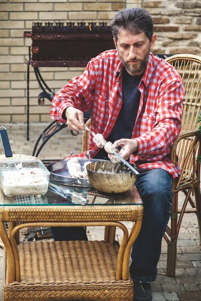 Человек на пикнике полоски мяса на шампуре — стоковое фото