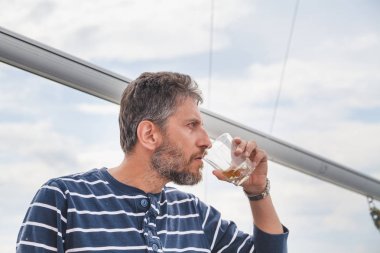 sakallı adam viski yatta içecekler.