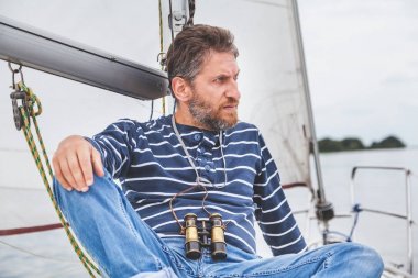 Yelkenli yat güvertede Kaptan sakallı oturur