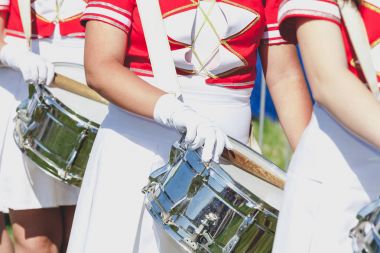 Kız üniformalı parlak davul sopa üzerinde koymak