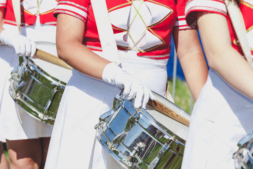 Girl in uniform put on brilliant drum sticks