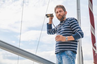 sakallı adam viski yatta içecekler.