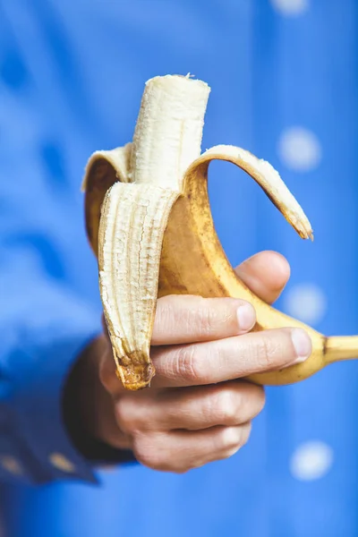 Hand of man holding  banana bitten — Stock Photo, Image