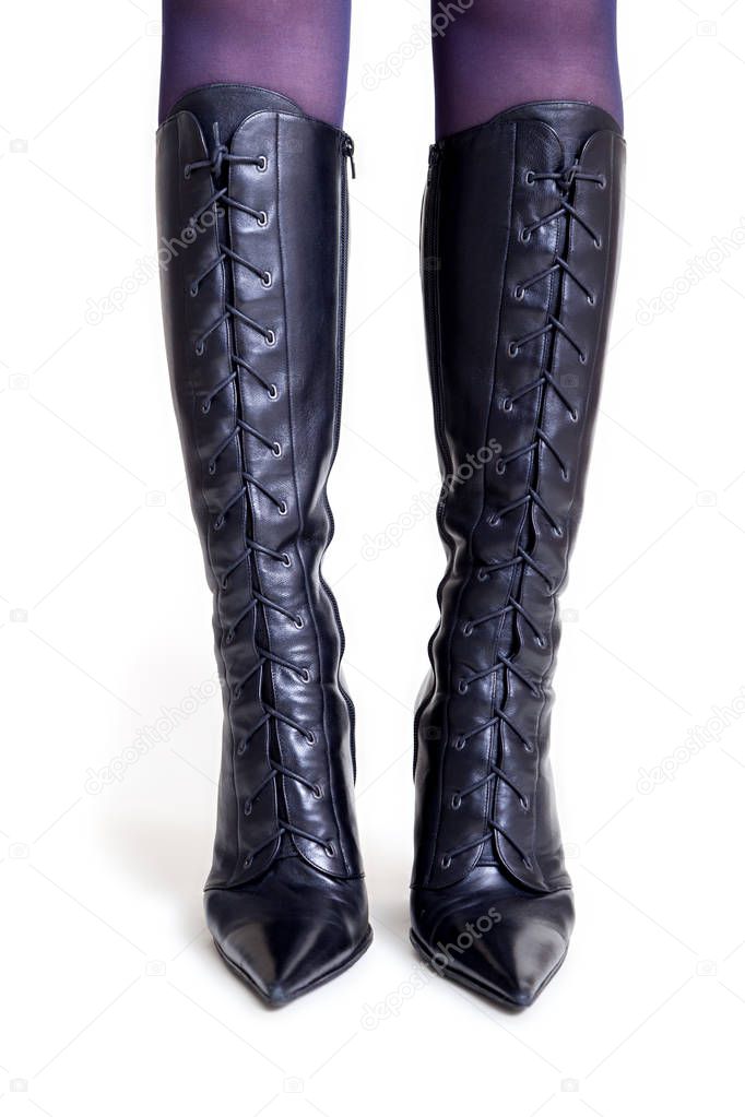 Slender female legs in high leather boots front view