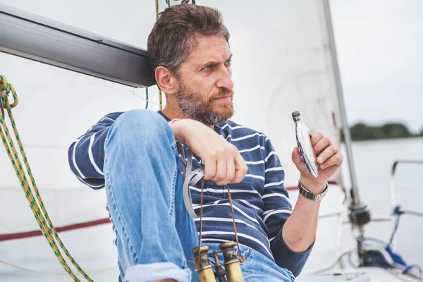 Homem com barba senta-se no convés do iate à vela — Fotografia de Stock