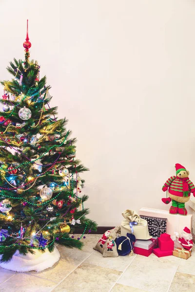 Christmas tree and gifts stand on white wall background — Stock Image Christmas tree and gifts stand on white wall background Royalty Free Stock Images