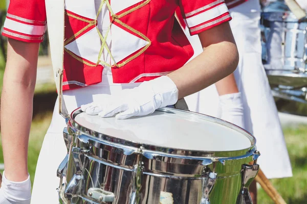 Mädchen in Uniform legte behandschuhte Hand auf glänzende Trommel — Stockfoto