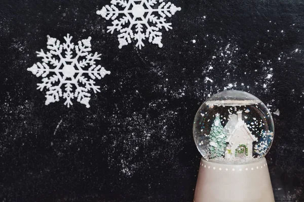 Glazen bal met sneeuwvlok op donkere achtergrond — Stockfoto
