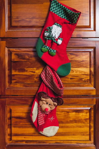 Two red New Year boots weigh on polished furniture