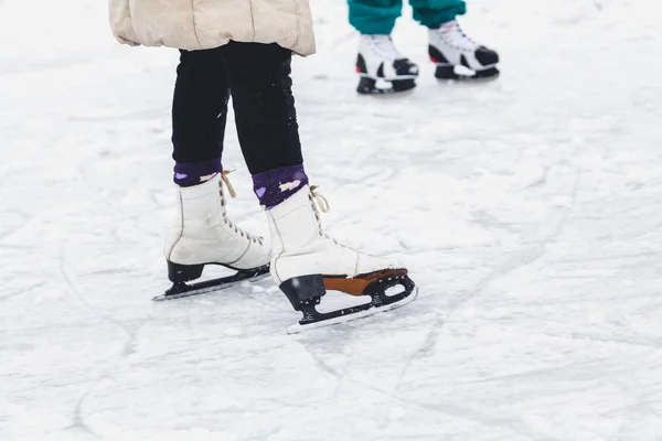 Les jambes dans les patins de sport sont roulées sur la glace — Photo