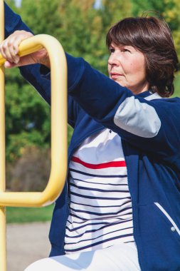 yaşlı kadın gerçekleştirir yaz çömelme spor zemin