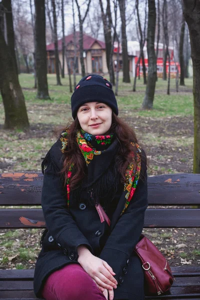 Belle jeune femme en écharpe russe assise sur un banc — Photo