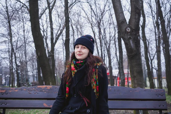 Belle jeune femme en écharpe russe assise sur un banc — Photo