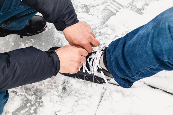 Hommes mains détacher la ficelle sur les femmes chaussures de skate — Photo