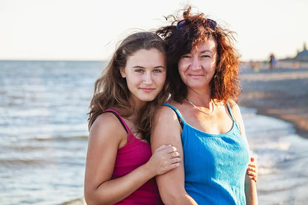 Cute mommy and adult daughter stand on seashore — Stock Photo, Image