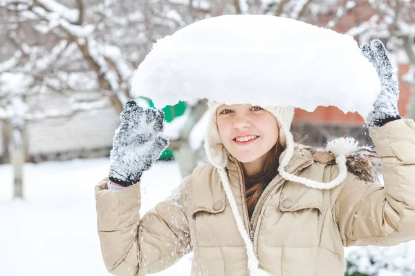 Jovencita sosteniendo un gran pedazo de nieve en su cabeza —  Fotos de Stock
