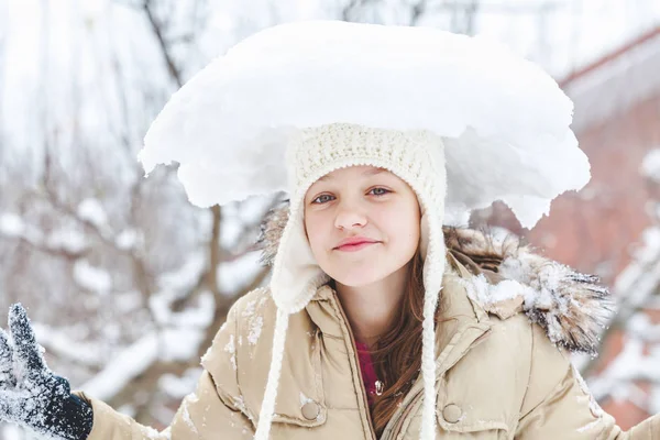 Jovencita alegre con pedazo de nieve en la cabeza —  Fotos de Stock
