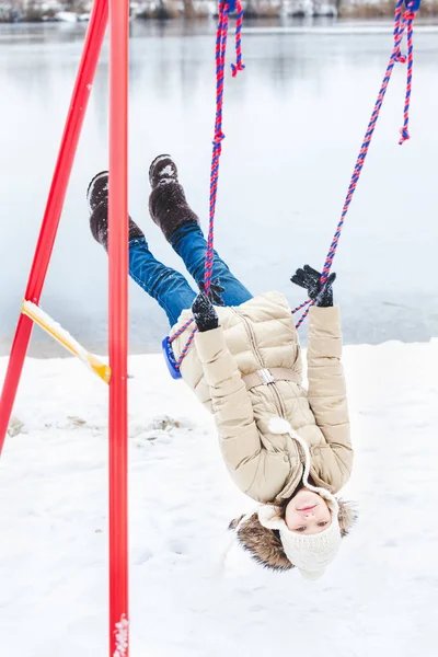 Jovencita colgando boca abajo en el columpio en invierno —  Fotos de Stock