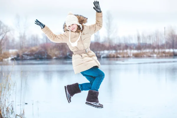 Jeune fille pendue en saut sur l'étang d'hiver — Photo