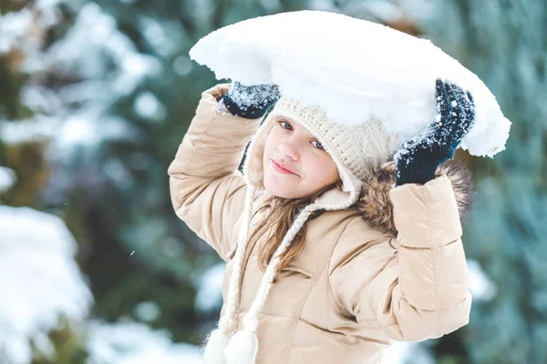 Joven chica sostiene pedazo de nieve en su cabeza —  Fotos de Stock
