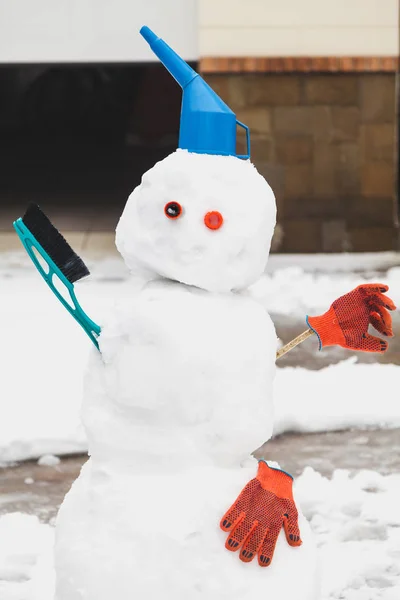 Bonhomme de neige drôle se tient devant le garage — Photo