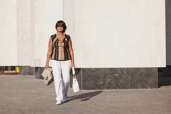 Mujer adulta linda caminando por la ciudad — Foto de Stock