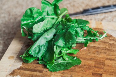 roka yalan yeşil yaprakları kesme tahtası üzerinde yıkanmış