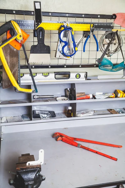 Metal hung bench with tools and pipe wrench