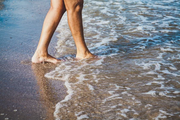 Женщина, гуляющая по морскому пляжу — стоковое фото