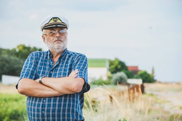 Oudere kapitein op de kust — Stockfoto