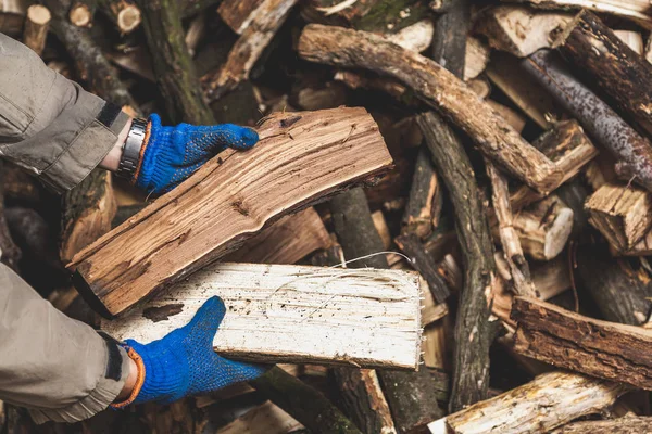 Руки в перчатках держат деревянные бревна — стоковое фото