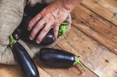 El ahşap kurullarında çantasından patlıcan alır