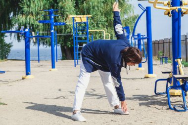 yaşlı kadın gerçekleştirir eğimli egzersizleri yaz spor zemin