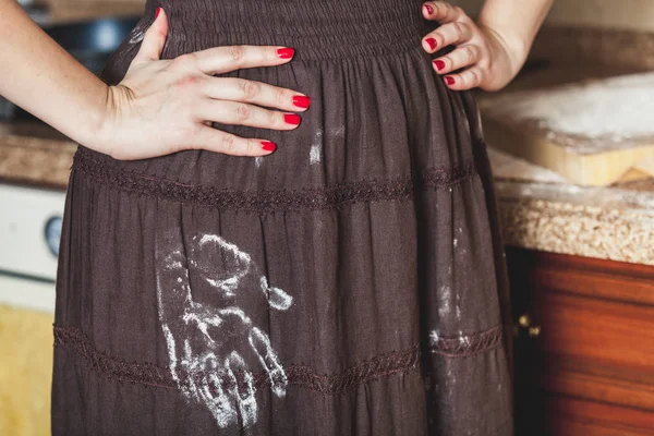 Kvinna som står i köket, på kjol av mjöl trace palm — Stockfoto