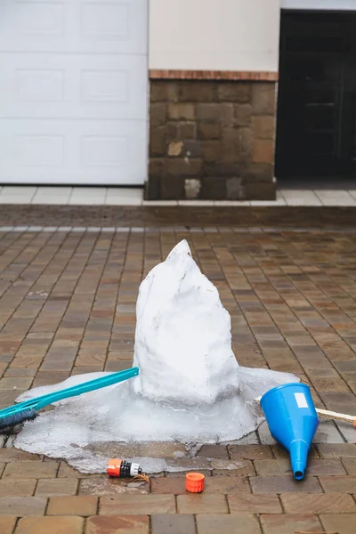 Remains of melted snowman on paving slab