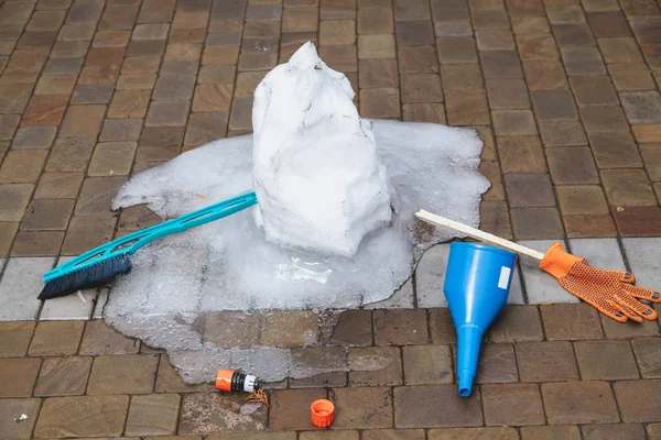 Remains of melted snowman on paving slab