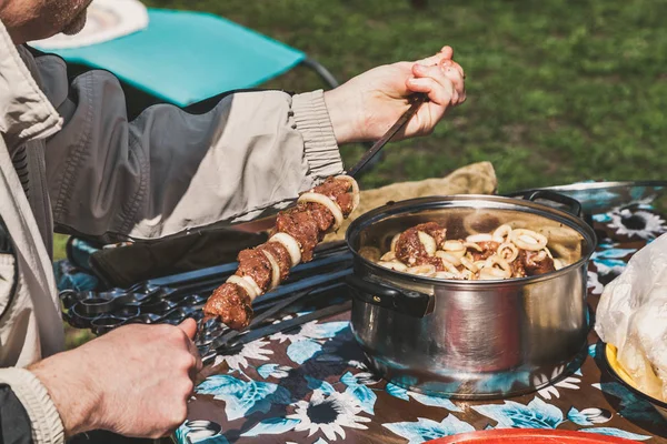 Руки нанизывают куски мяса на стальной шампур крупным планом — стоковое фото