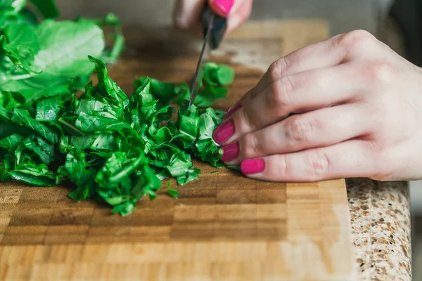 As mãos de mulher cortam folhas verdes de arugula — Fotografia de Stock