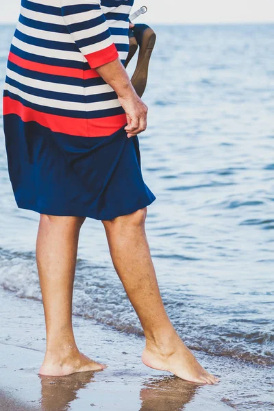 Женщина идет вдоль песчаного пляжа — стоковое фото