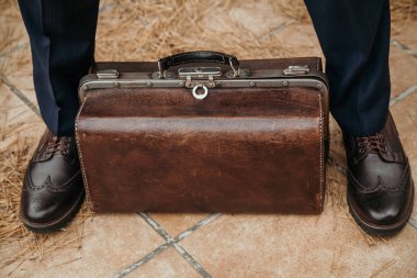 Deri çanta adam bacaklar arasında.