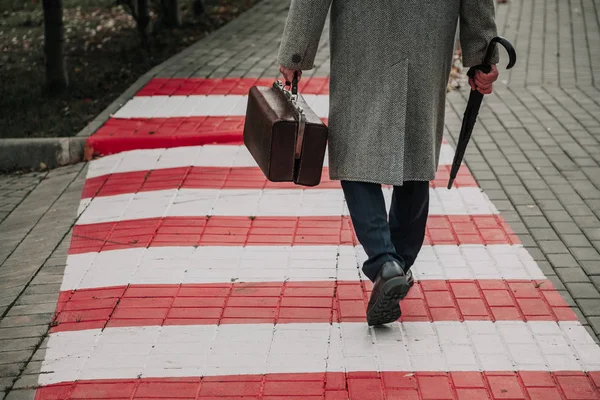 Hombre con bolsa y abrigo camina por la calle — Foto de Stock