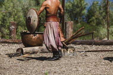 Eski savaşçı yuvarlak kalkan büyük arka planda tutar. 