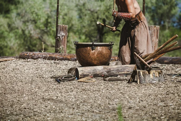 Ancient warrior in broad trousers plays on tulumbas — Stock Photo, Image